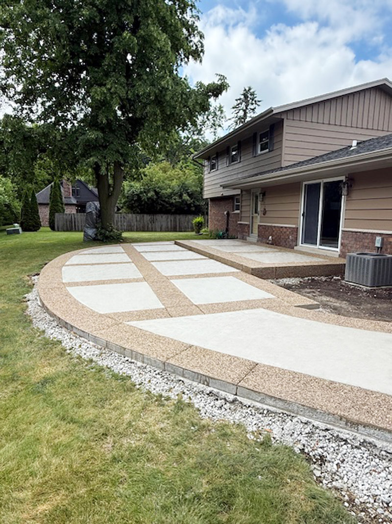 Decorative patio with exposed aggregate border and picture-frame effect using white broomed concrete finish