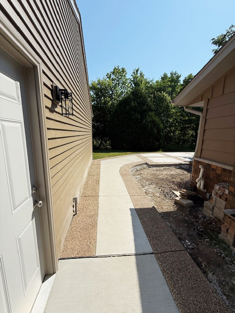 Sidewalk and walkway with exposed aggregate border and white broomed concrete finish