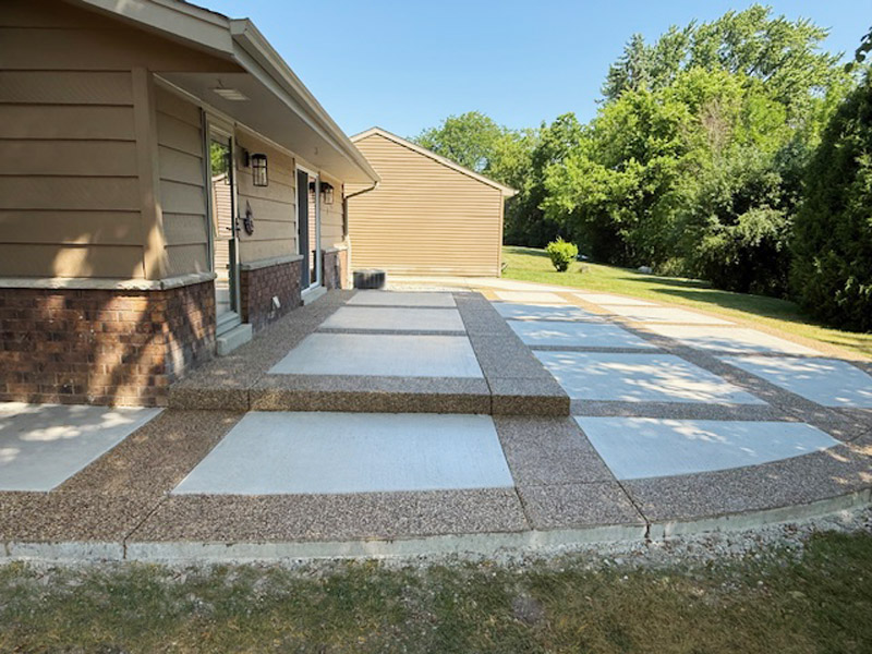 Decorative patio with exposed aggregate border and picture-frame effect using white broomed concrete finish