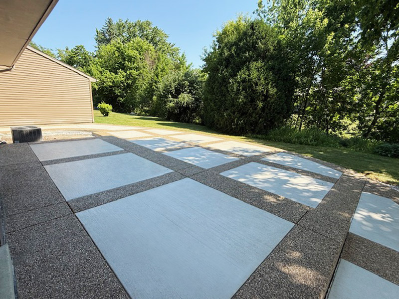 Decorative patio with exposed aggregate border and picture-frame effect using white broomed concrete finish