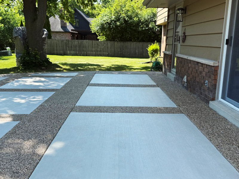 Decorative patio with exposed aggregate border and picture-frame effect using white broomed concrete finish