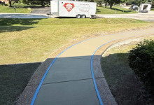 Sidewalk and walkway with exposed aggregate border and white broomed concrete finish