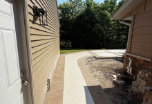 Sidewalk and walkway with exposed aggregate border and white broomed concrete finish