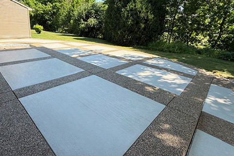 Decorative patio with exposed aggregate border and picture-frame effect using white broomed concrete finish